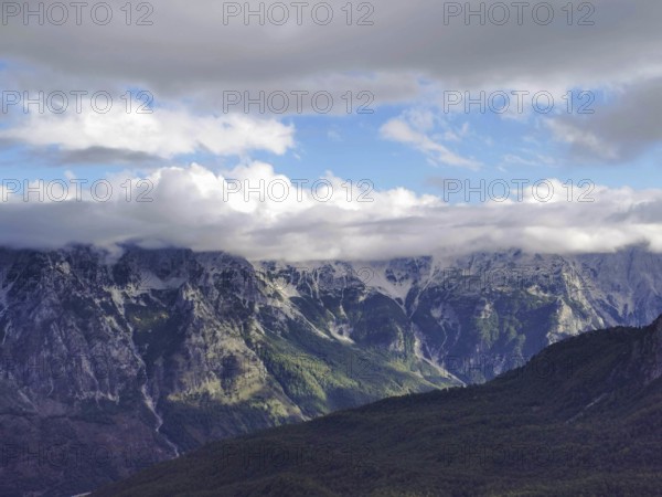 Fascinating mountain landscape with clouds floating over the peaks and light play in the sky, Peaks of the Balkans, hiking in the Albanian Alps National Park, Albania