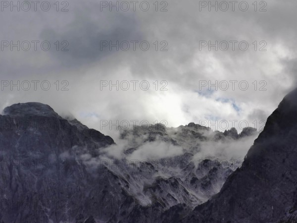 Dramatic cloud formations over rocky mountain peaks, mostly in shades of gray, Peaks of the Balkans, hiking in the Albanian Alps National Park, Albania