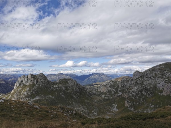 Mountain panorama, impressive rock massif under a dynamic cloudy sky in wild surroundings, Peaks of the Balkans, hiking in the Albanian Alps National Park, Albania
