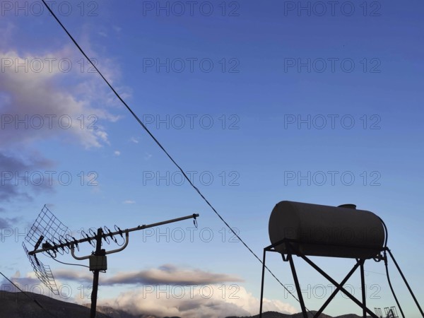 Antenna and water tank stand out against the evening sky, Himare, Albania