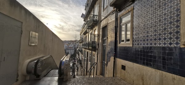 Evening atmosphere on a staircase with a view of decorated house facades and tiles, Lisbon, Portugal