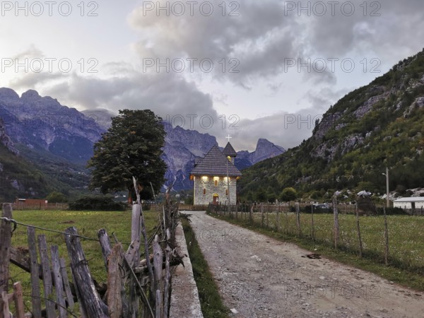 Lonely church in Theth, in a mountainous landscape at dusk with peaceful atmosphere, Peaks of the Balkans, hiking in the Albanian Alps National Park, Albania
