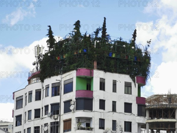 Modern building with green roof garden and colorful building elements, jungle on the roof, urban gardening, Georgia