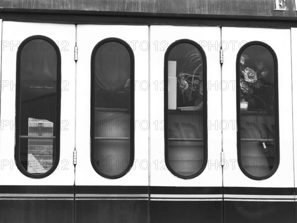 Monochrome photo of the windows of a nostalgic wagon on a steam locomotive, Rosen, Germany