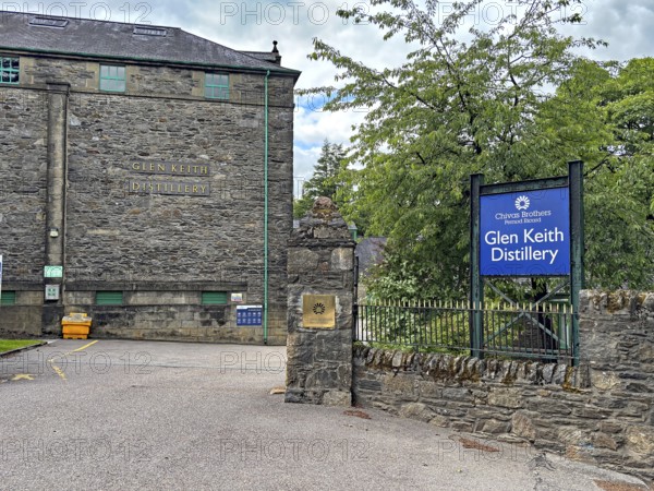 Entrance to Glen Keith Distillery with stone buildings and signs in a wooded area, Keith, Aberdeenshire, Scotland, Great Britain