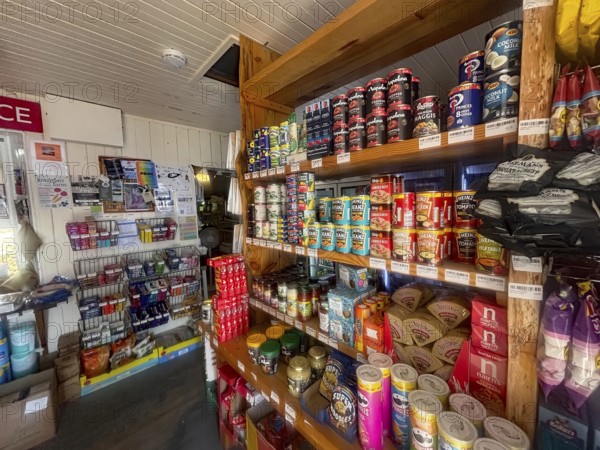 A small shop with stocked shelves full of cans and colorful food products, the only shop in the remote village of Knoydart, Scotland, Great Britain