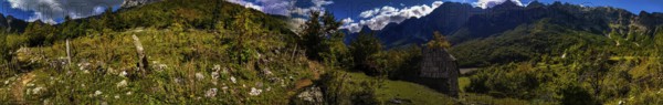 Panorama, sun-drenched and dramatic forest landscape with huts in bright colors, contrasting lighting, Albanian Alps National Park