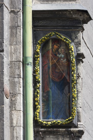 Sacred image decorated with flowers on a house wall, Lviv, Ukraine