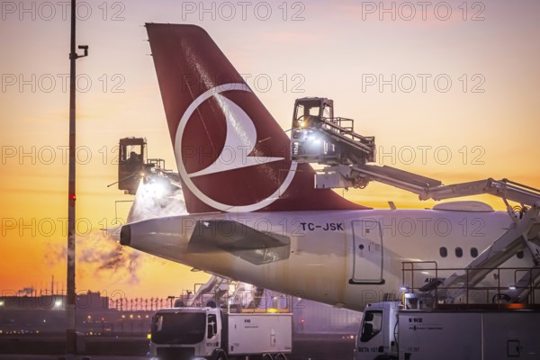 Frost at the airport in front of sunrise. A Turkish Airways aircraft is de-iced. Airbus A321-231. Fraport airport. Frankfurt am Main, Hesse, Germany
