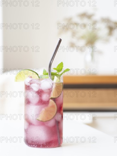 Pink refreshing cocktail with lime, mint, and metal straw, creating a cool summer drink