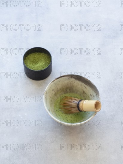 Freshly prepared matcha green tea with a bamboo whisk and powdered tea