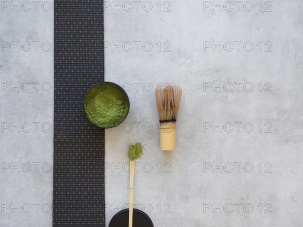 Matcha powder in a bowl with bamboo chasen whisk, preparing traditional green tea