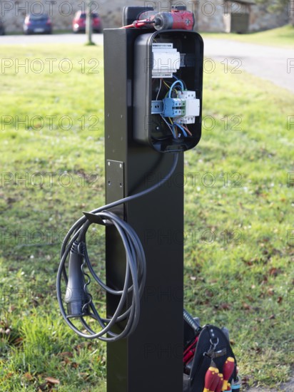 Electric vehicle charging station showing internal wiring during installation process