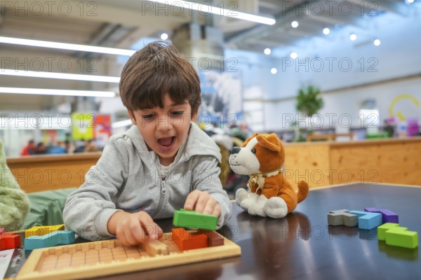 Young child experiencing joy and concentration while playing with colorful wooden building blocks and a puzzle board, engaging in educational activity and childhood development