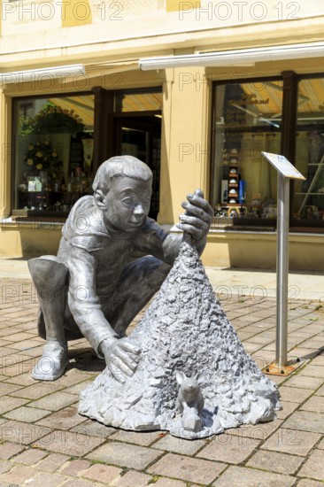 Silver figure claw boy by Christoph Rossner in Petersstraße, stop on the Siberweg adventure trail through the old town of Freiberg, Saxony, Germany