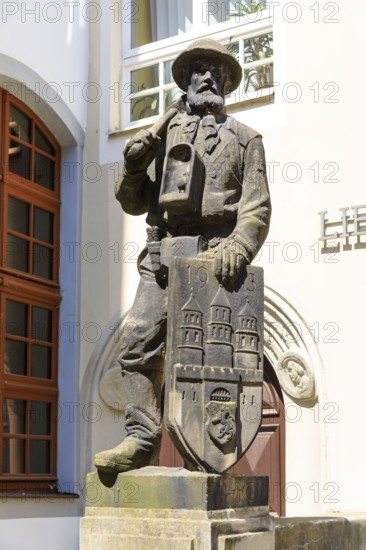 Bergmannsdenkmal, sandstone figure of a miner with coat of arms, behind the town hall in Freiberg, Saxony, Germany