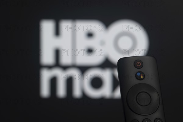 Dhaka, Bangladesh- 21 Jan 2026: Close-up of a smart TV remote control against a blurred HBO max logo