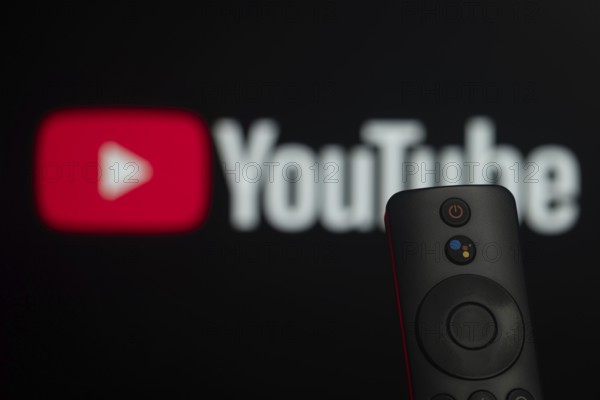 Dhaka, Bangladesh- 21 Jan 2026: Close-up of a smart TV remote control against a blurred youtube logo