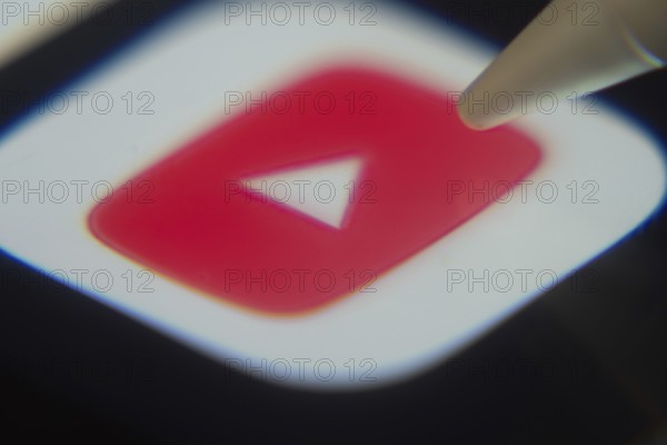 Dhaka, Bangladesh- 06 Dec 2025: Close-up of the youtube app on a screen with a stylus pointing at it