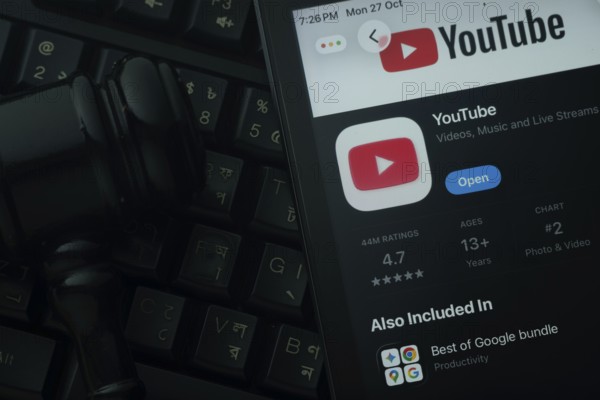Dhaka, Bangladesh- 28 Oct 2025: An iPad displaying the youtube app against a judge's gavel and dark keyboard background