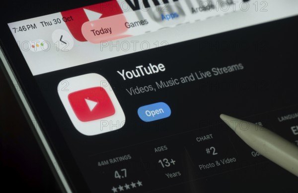 Dhaka, Bangladesh- 30 Oct 2025: Youtube app displayed on a iPad screen in dark mode with a digital pen pointing at it