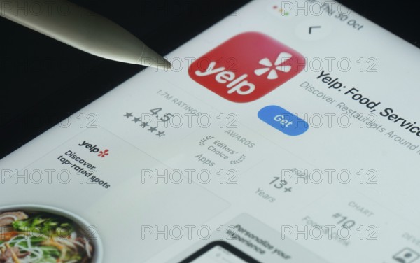 Dhaka, Bangladesh- 30 Oct 2025: Yelp app on a iPad screen with a pen pointing at the install option