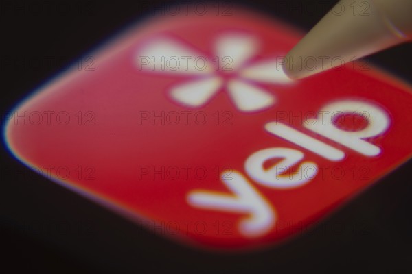 Dhaka, Bangladesh- 06 Dec 2025: Close-up of the Yelp app on a screen with a stylus pointing at it