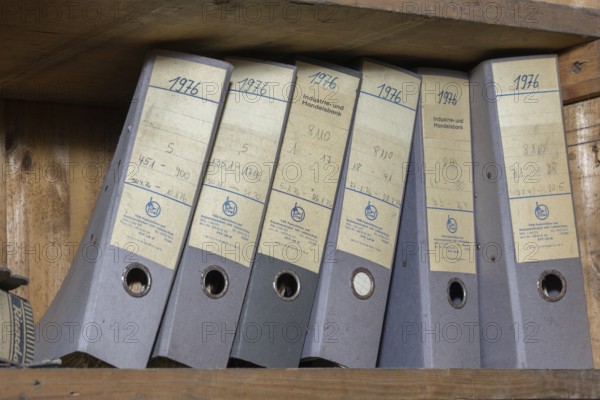 Shelves with dusty folders in the administration of a former GDR factory, Lost Place, Saxony-Anhalt, Germany