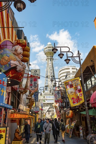 Lots of colorful signs in a pedestrian zone with shops and restaurants, behind Tsutenkaku Tower, Shinsekai, Osaka, Japan