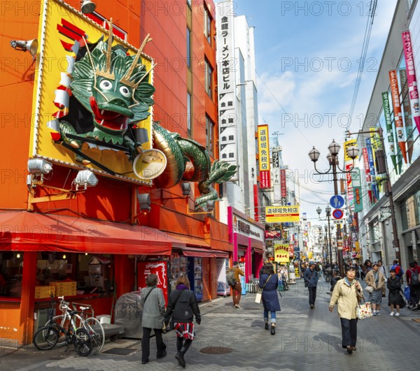 Dragon figure at a restaurant, lots of colorful signs in a pedestrian zone with shops and restaurants, Dotonbori, Osaka, Japan