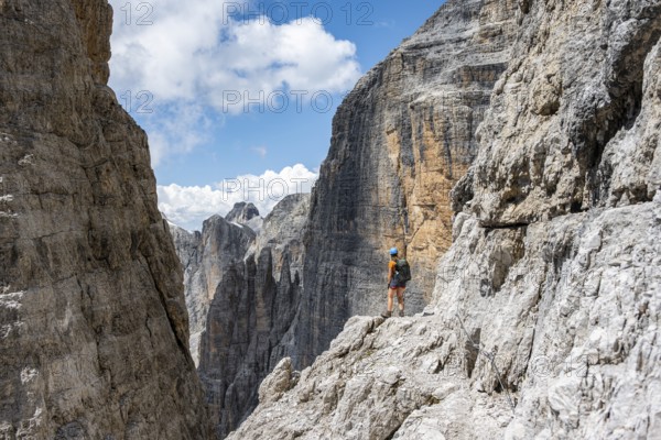 Hikers on the Sentiero Brentari via ferrata in front of cliffs, Brenta Mountains, Brenta-Adamello Natural Park, Trentino, Italy