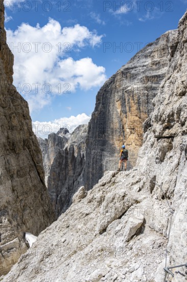 Hikers on the Sentiero Brentari via ferrata in front of cliffs, Brenta Mountains, Brenta-Adamello Natural Park, Trentino, Italy