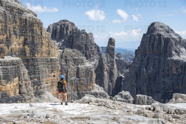 Hikers on the Sentiero Brentari hiking trail in front of cliffs, Brenta Mountains, Brenta-Adamello Natural Park, Trentino, Italy