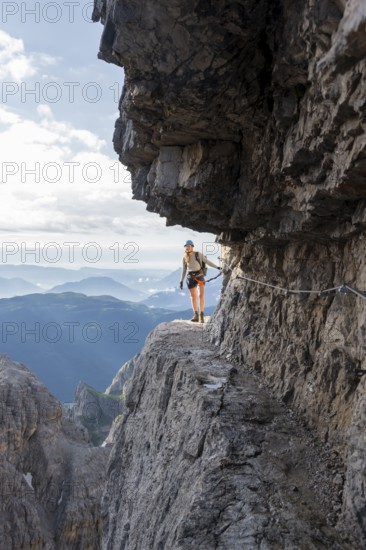 Climbers on a rock band, Bocchette Centrale band trail, via ferrata in the Brenta Mountains, Brenta-Adamello Natural Park, Trentino, Italy