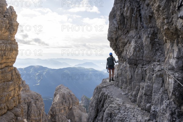 Climbers on a rock band, Bocchette Centrale band trail, via ferrata in the Brenta Mountains, Brenta-Adamello Natural Park, Trentino, Italy