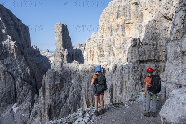 Mountaineers look at Campanile Alto pinnacle, Bocchette Centrale band trail, via ferrata in the Brenta Mountains, Parco Naturale Brenta-Adamello, Trentino, Italy