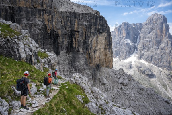 Three mountaineers on a hiking trail, rocky mountain landscape, Via Ferrata SOSAT via ferrata, Brenta Mountains, Trentino, Italy