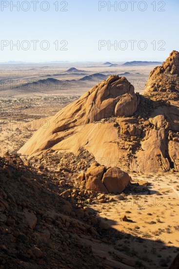 Impressive rock formations cast shadows over the endless desert, Spitzkoppe, Namibia