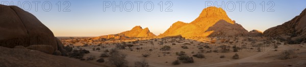 Mountains in the desert at sunset with bright shades of orange on the horizon, Spitzkoppe, Namibia