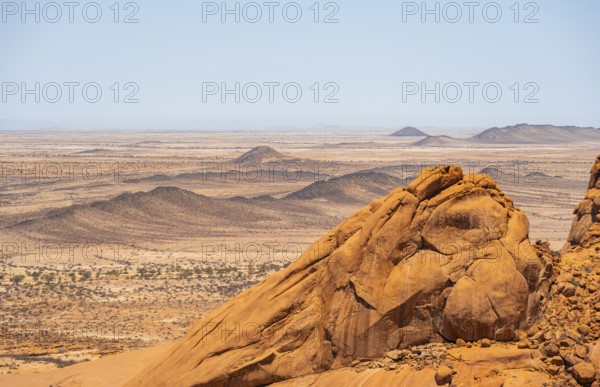 View of extensive desert landscape and distinctive rock formations on the horizon, Spitzkoppe, Namibia