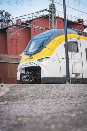 Modern locomotive on rails against an industrial backdrop under grey skies, opening of the Hermann Hesse Railway, Calw, Germany