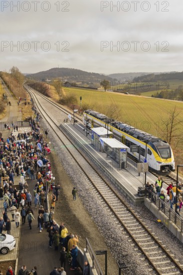 Numerous people gather at a train station in a rural area with rolling hills in the background, opening of the Hermann Hesse Railway, Calw, Germany