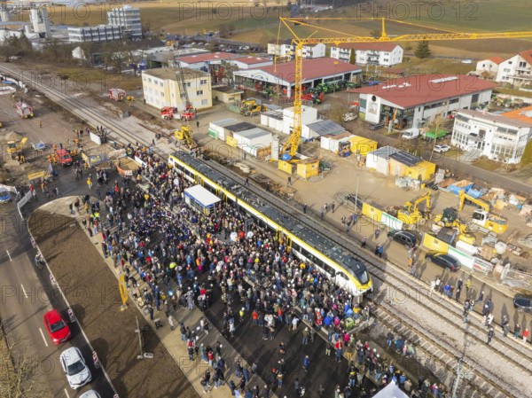 People gather around a train on a construction site, aerial view with landscape in the background, opening of the Hermann Hesse Railway, Calw, Germany