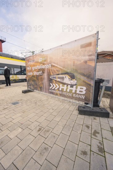 Advertising banner for the Hermann Hesse Railway on a platform, with a train in the background, opening of the Hermann Hesse Railway, Calw, Germany