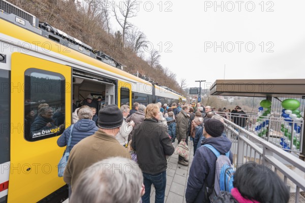People standing on a platform next to a decorated train, platformside celebration, opening of the Hermann Hesse Railway, Calw, Germany