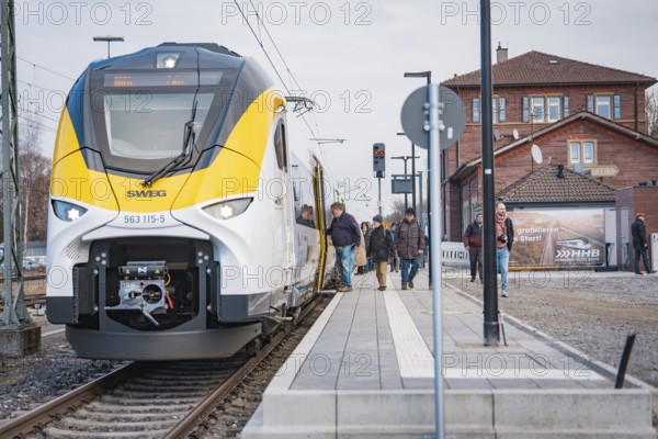 A train on the platform with people and buildings in the background, opening of the Hermann Hesse Railway, Calw, Germany
