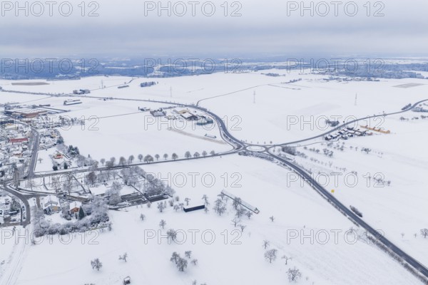 Snow-covered intersection in the middle of a vast winter landscape with surrounding villages, substation, Jettingen, Germany