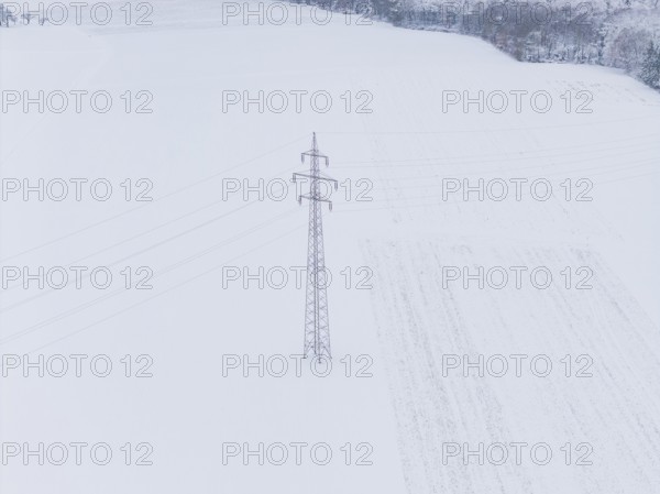 A snow-covered wide field with a single power pole in the middle, substation, Jettingen, Germany