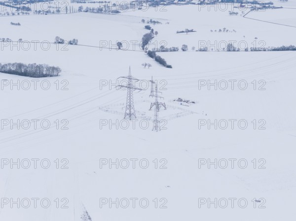 Snowy landscape with power lines running through a wide field, substation, Jettingen, Germany
