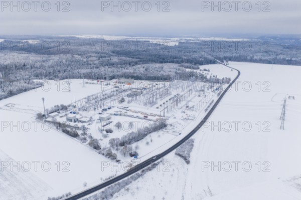 Snowy substation and road in the midst of a winter landscape with thick forests, substation, Jettingen, Germany